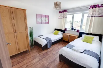 a bedroom with two beds and a window at Meridian Apartment Suites in Southend-on-Sea