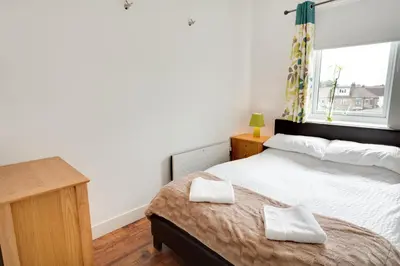 a bedroom with a bed with two towels on it at Meridian Apartment Suites in Southend-on-Sea