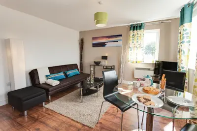 a living room with a couch and a table at Meridian Apartment Suites in Southend-on-Sea