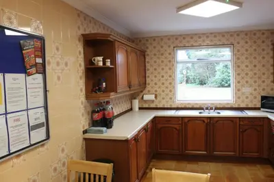 a kitchen with wooden cabinets and a window at Brookside Lodge in Baldock