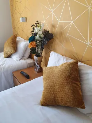 a bedroom with a bed and a vase of flowers on a table at The Nags Head in Norwich
