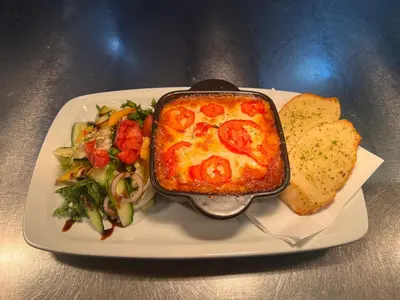 a white plate with a dish of pizza and a salad at Holiday Inn Express Harlow by IHG in Harlow