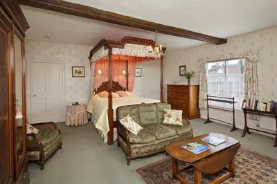 a bedroom with a canopy bed and a couch at Haughley House in Stowmarket