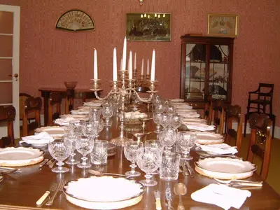 a long table with white plates and glasses on it at Haughley House in Stowmarket