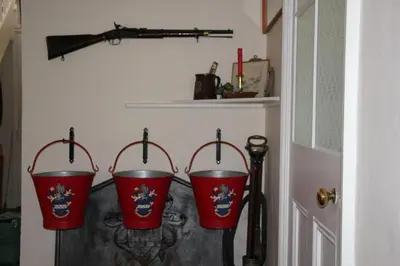 three red buckets are hanging on a wall at Haughley House in Stowmarket