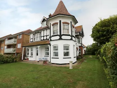 an old house with a turret on a yard at Flat 1, Cambridge Court in Frinton-on-Sea