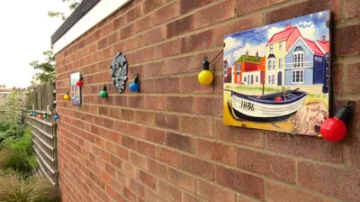 a painting of a house on a brick wall at Poplars in Aldeburgh