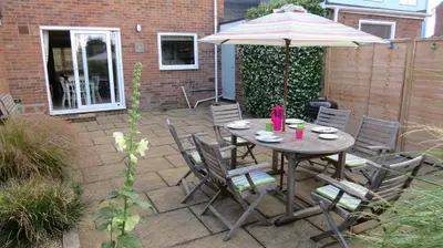 a table and chairs with an umbrella on a patio at Poplars in Aldeburgh