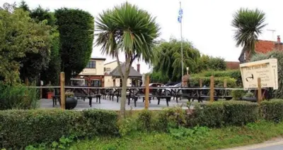 a group of tables and palm trees in a park at The Blackwater Suite in West Mersea