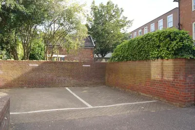 a brick wall with a tennis court in a parking lot at 1 WATER PUMP HOUSE in Bury Saint Edmunds