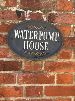 a water pump house sign on a brick wall at 1 WATER PUMP HOUSE in Bury Saint Edmunds