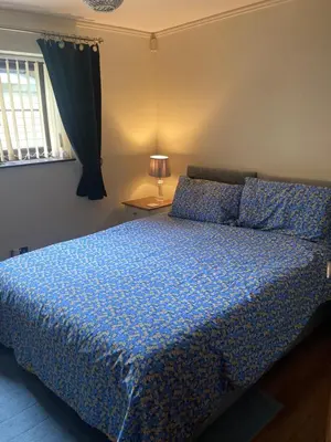 a bedroom with a bed with a blue comforter at 2 bedrooms Bell Cottage in Hoddesdon