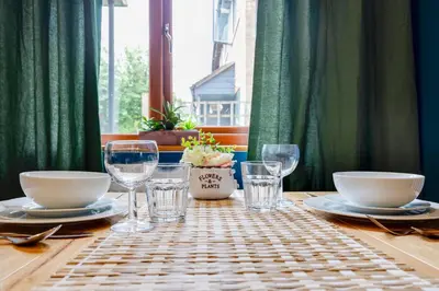 a wooden table with plates and glasses on it at Fully refurbished 1 bedroom in Cambridge