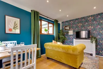 a dining room with blue walls and a yellow chair at Fully refurbished 1 bedroom in Cambridge