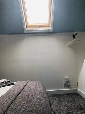 a bedroom with a bed and a window at AC Hideout in Rochford