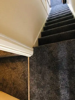 a staircase with black carpeted floors and a stair case at AC Hideout in Rochford