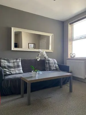 a living room with a blue couch and a table at Eclipse Apartment No 2 in Newmarket