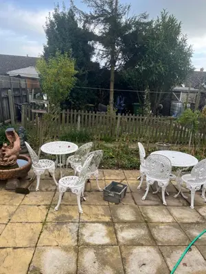 a patio with white tables and chairs and a fence at Seaside resort in Felixstowe