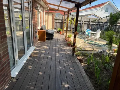 a porch with a wooden floor and glass doors at Seaside resort in Felixstowe