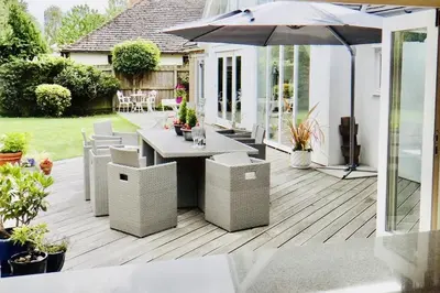 a patio with an umbrella and a table and chairs at The Thorpe Guesthouse in Huntingdon