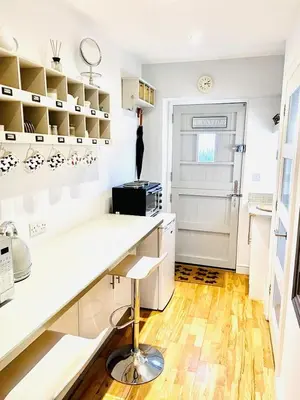 a kitchen with a white counter and a table at The Thorpe Guesthouse in Huntingdon
