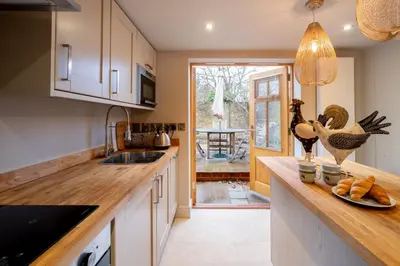 a kitchen with a sink and a counter with a plate of food at Church Farm Lodge in Aldeburgh