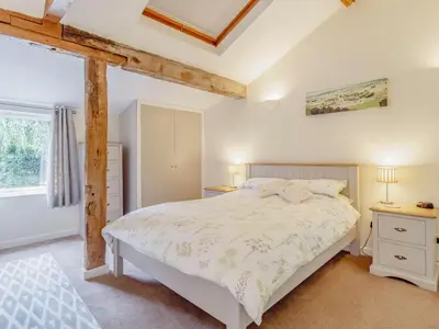 a bedroom with a white bed and a window at The Hen House in Diss