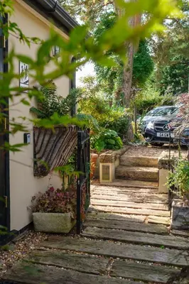 a driveway leading to a house with a gate at Quavers Rest - quintessential little home & hot tub available ! in Rushford