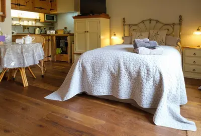 a bedroom with a bed with a white blanket at Quavers Rest - quintessential little home & hot tub available ! in Rushford