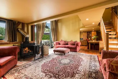 a living room with red furniture and a fireplace at Corner Farm Barn in Halesworth