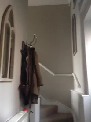 a hallway with a coat hanging on a wall at Little Bury Barn in Bury Saint Edmunds