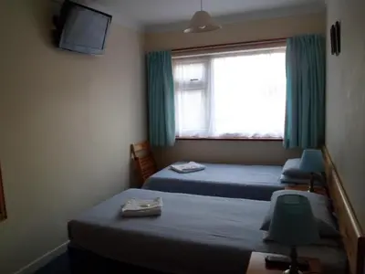 a hotel room with two beds and a window at Carlton Lodge in Cambridge