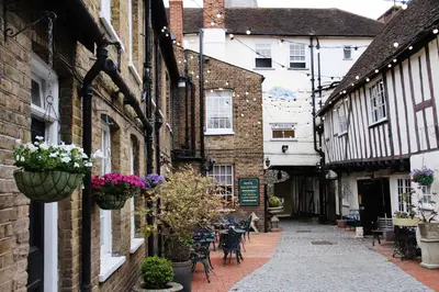 an alley in an old town with flowerpots on the buildings at The Blue Boar - Maldon in Maldon