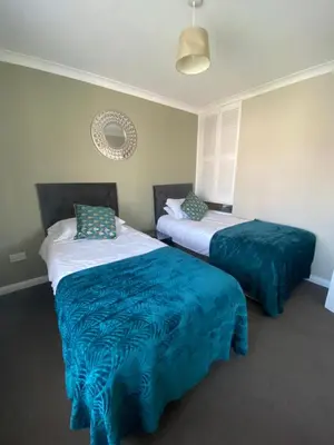 a bedroom with two beds with blue and white sheets at By Buildersbeds - Hill House 3 Bedrooms in Romford