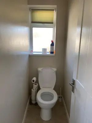 a small bathroom with a toilet with a window at By Buildersbeds - Hill House 3 Bedrooms in Romford