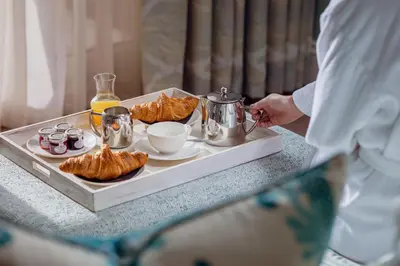 a man standing at a table with a tray of pastries at Roslin Beach Hotel in Southend-on-Sea