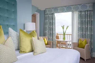 a bedroom with a white bed with yellow pillows at Roslin Beach Hotel in Southend-on-Sea