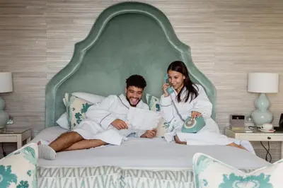 a man and a woman sitting on a bed at Roslin Beach Hotel in Southend-on-Sea