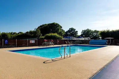 a swimming pool with a metal railing around it at Camping Pods, Carlton Meres Holiday Park in Rendham