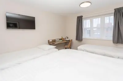 two beds in a room with a tv on the wall at The Aviator, formerly Smugglers Cove, Clacton On Sea by Marston's Inns in Clacton-on-Sea