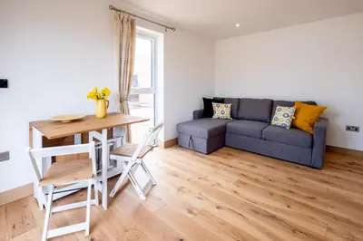 a living room with a couch and a table at Maple - Three Tuns Apartments - Pettistree, Wickham Market - by Aldeburgh Coastal Cottages in Pettistree