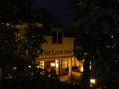 a lit up building with the lion inn at night at The Lion Inn in Chelmsford