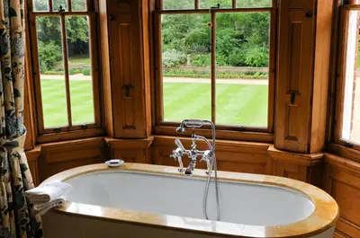 a bath tub in a room with windows at The Jockey Club Rooms in Newmarket
