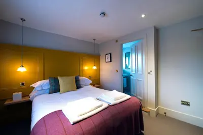 a bedroom with a large bed with two towels on it at The Coach House in Potton