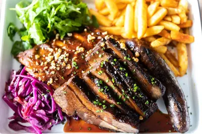 a plate of food with meat and fries and a salad at The Coach House in Potton