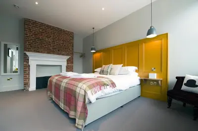a bedroom with a large bed and a fireplace at The Coach House in Potton