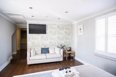 a living room with a couch and a tv on a wall at The Oyster Smack in Burnham on Crouch