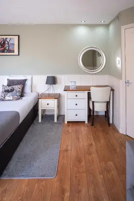 a bedroom with a bed and a desk and a mirror at The Oyster Smack in Burnham on Crouch