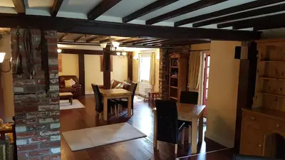 a living room with a table and a dining room at The Pelican Guesthouse in Ashwellthorpe