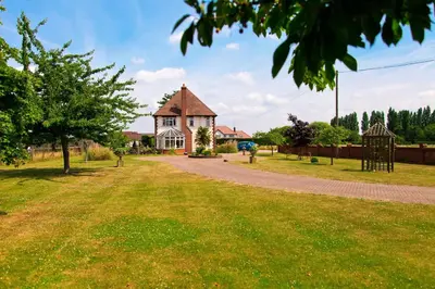 a house with a grassy yard in front of it at Elmcroft Guest House in Epping
